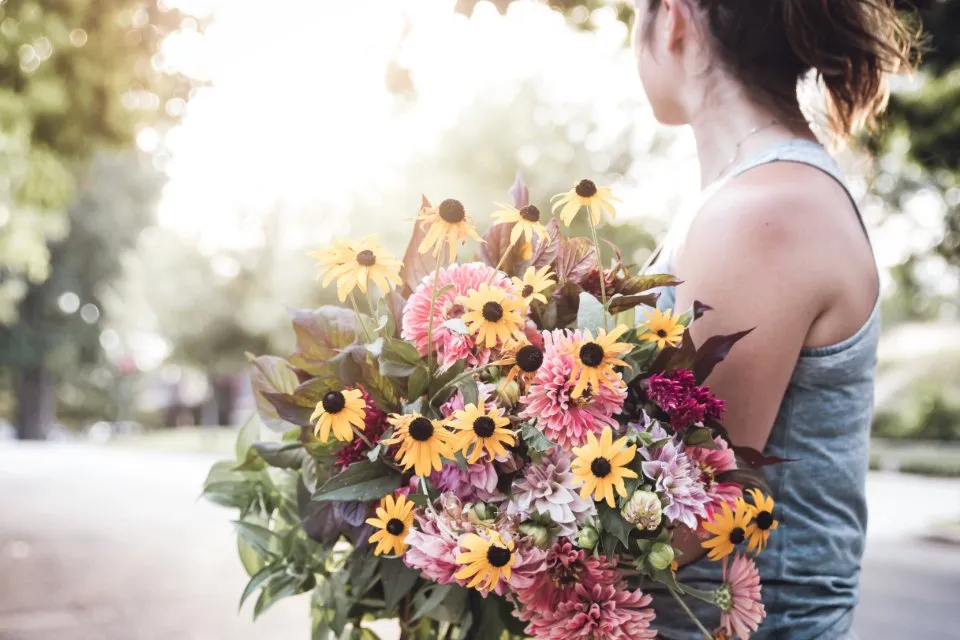 Mujer sujetando un gran ramo de flores silvestres